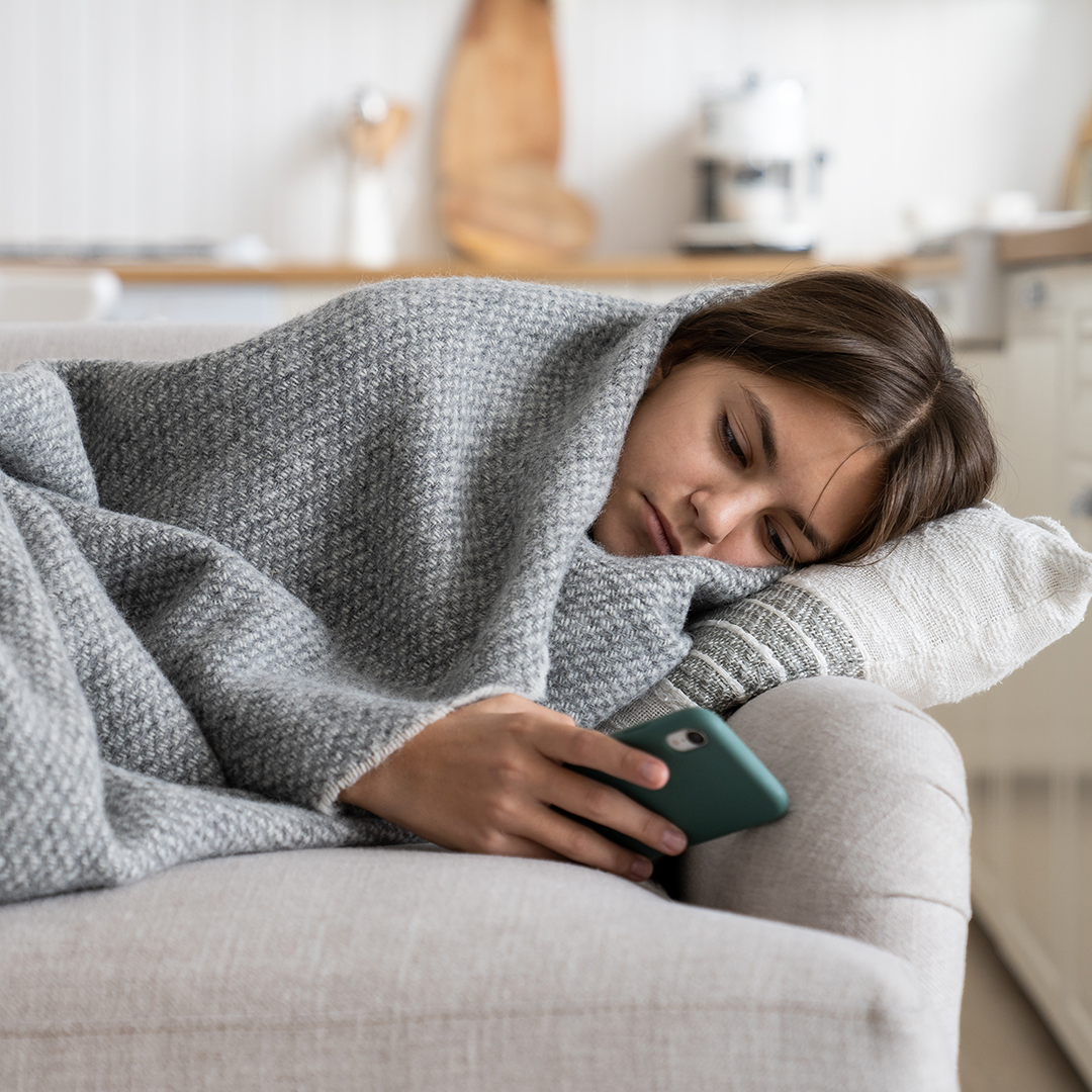 Chica joven en un sofá con problemas de salud mental que trabaja con la SwissDTx Patient App.